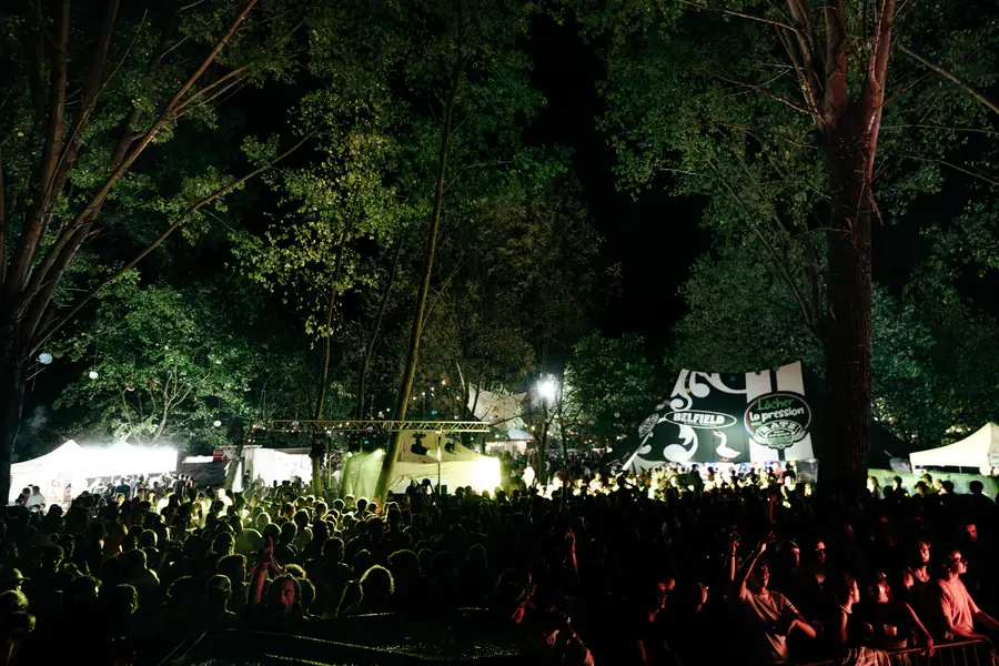 Foule de nuit sous les arbres éclairés du Parc de la Lère au Belfield Festival 2026