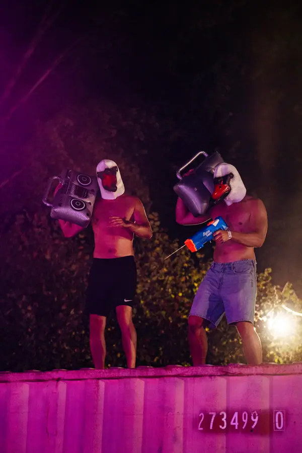 Deux bénévoles masqués en oie dansent sur un container rose au Belfield Festival 2026