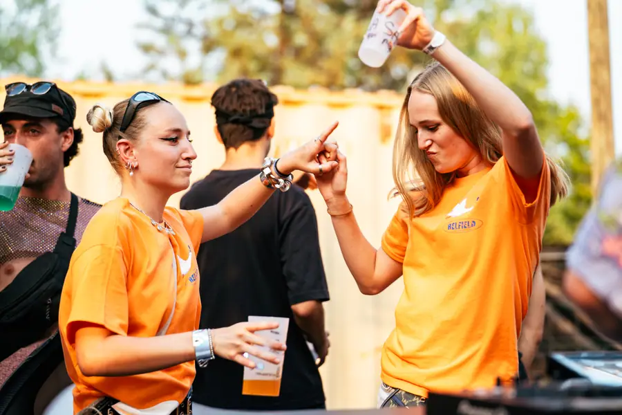 Bénévoles en t-shirt orange trinquent pendant le Belfield Festival 2026