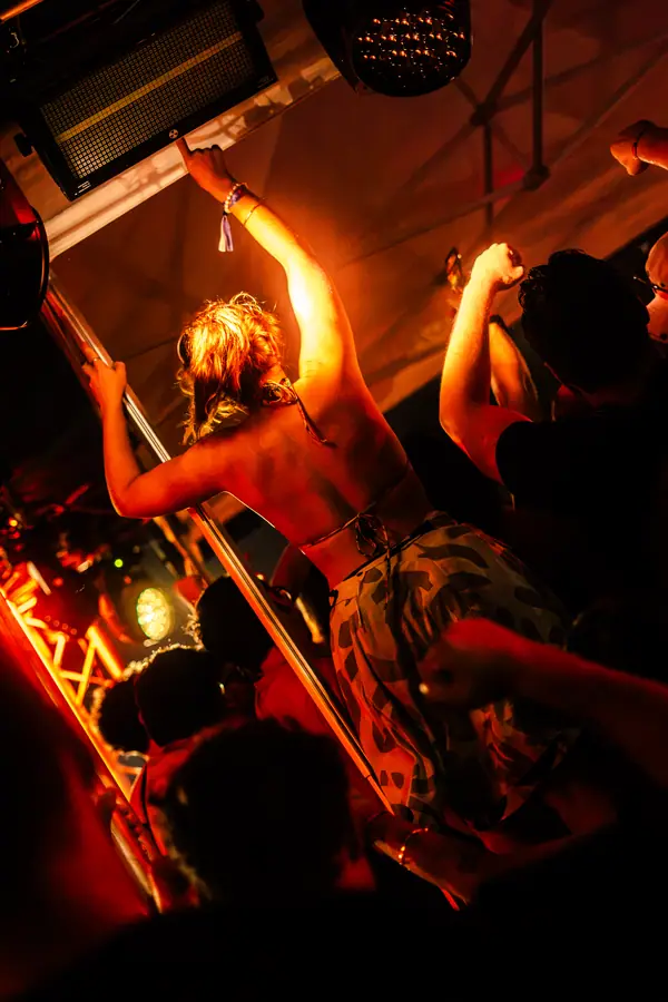 Festivalière bras levés dans la lumière orange du Belfield Festival 2026